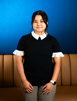 Sherling Garcia Vargas stands in front of a blue backdrop.